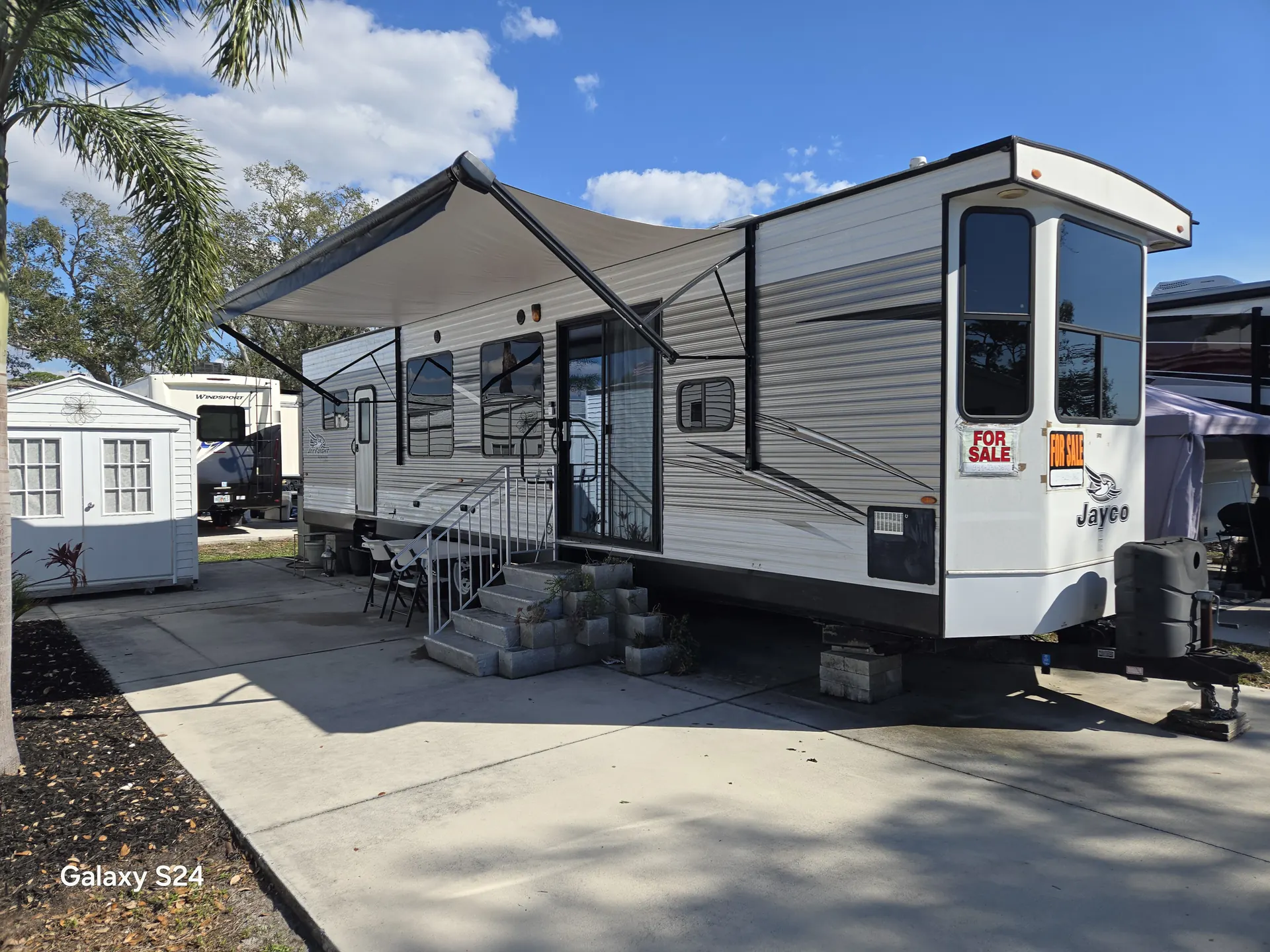 Jayco destination trailer with repaired patio awning extended at an RV park in Bradenton, FL